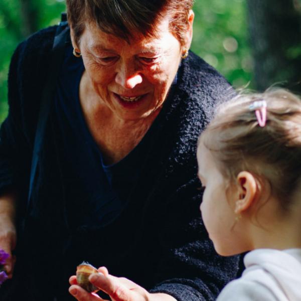women showing flowers to child