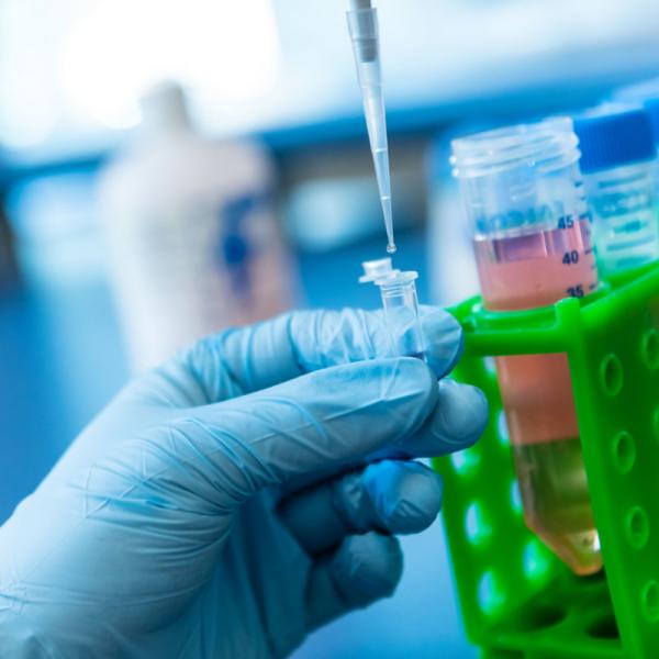 hand holding pipette in a lab