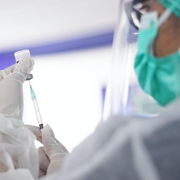 Syringe and vial with masked person