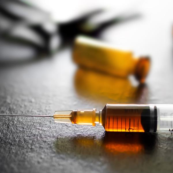 syringe with dark orange substance