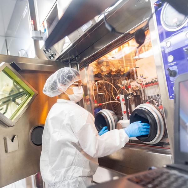 technician at machinery for radiochemistry processing hot cell 